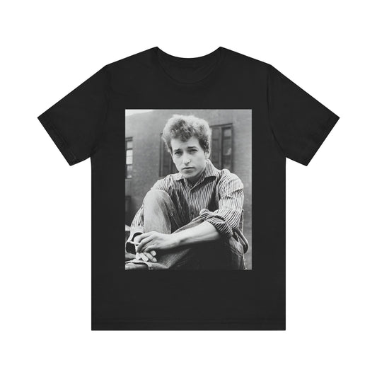 A black graphic t-shirt featuring a graphic of Bob Dylan from his 60s origins in folk music.