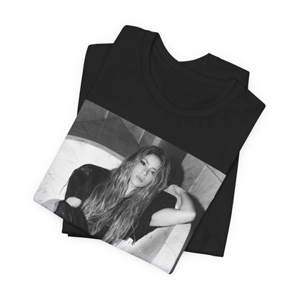 A black graphic t-shirt featuring a retro graphic related to Shakira's 'Hips Don't Lie' song or era.