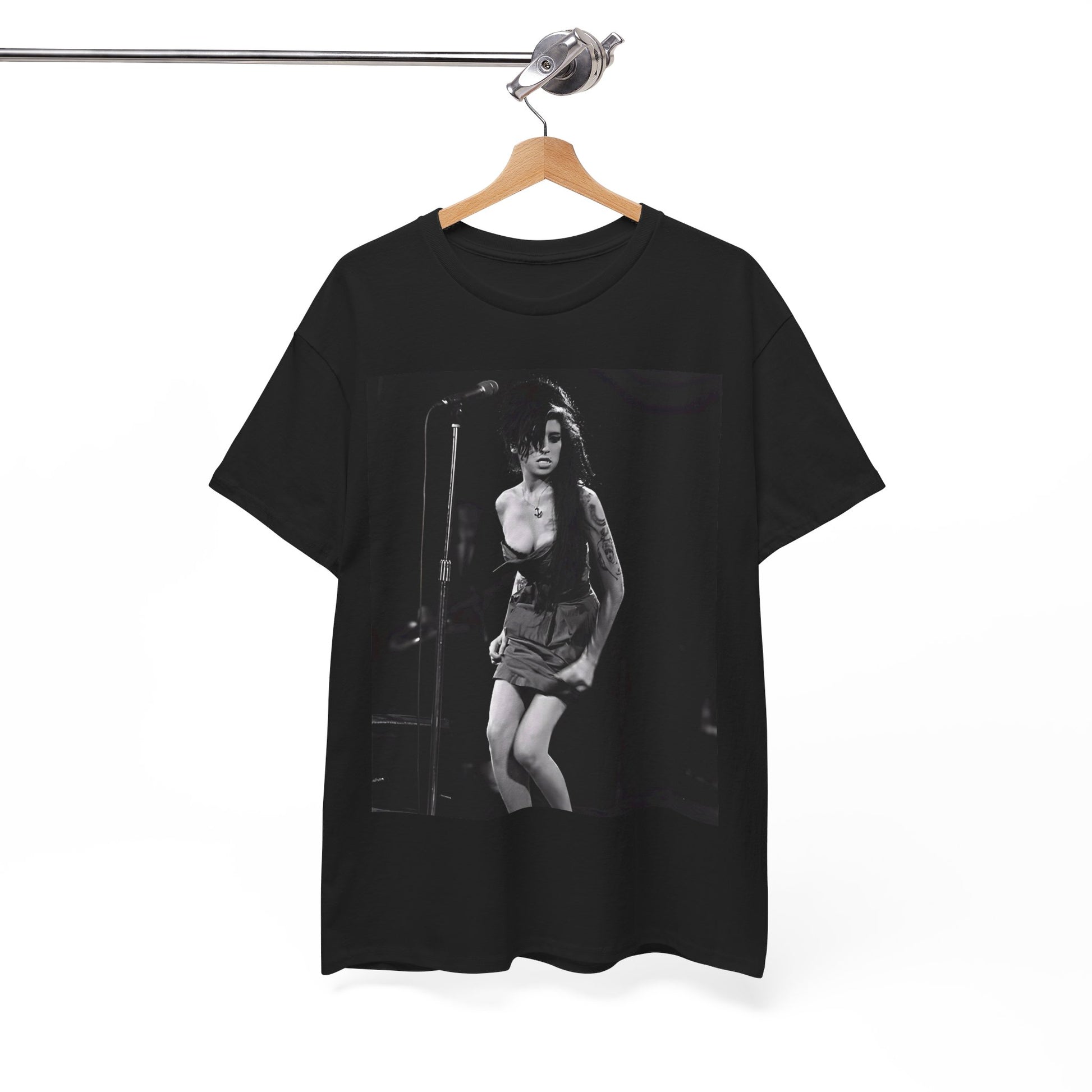 A black graphic t-shirt featuring a photo of Amy Winehouse performing live on stage at nightfall, with stage lighting effects.