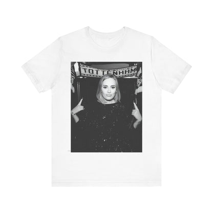 A black graphic t-shirt featuring a photo of Adele in a casual setting, surrounded by fans at a Tottenham event, showing her smiling or interacting.