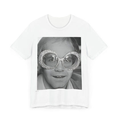 A black graphic t-shirt featuring a graphic of Elton John emphasizing his iconic glasses and fashion.