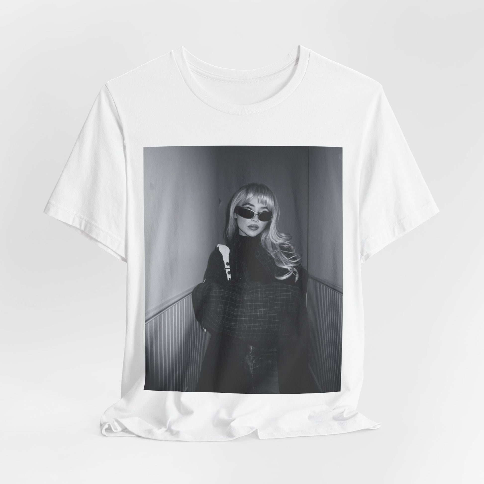 A black graphic t-shirt featuring a black and white glam pop diva graphic of Sabrina Carpenter.