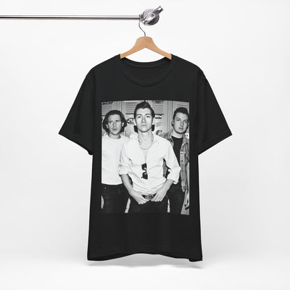 A black graphic t-shirt featuring a vintage-style design related to Arctic Monkeys' 'AM' album era, possibly with the album art or band imagery.