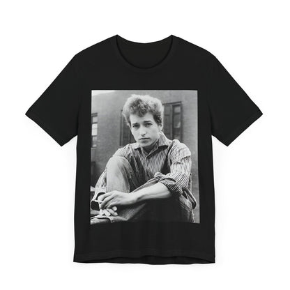 A black graphic t-shirt featuring a graphic of Bob Dylan from his 60s origins in folk music.