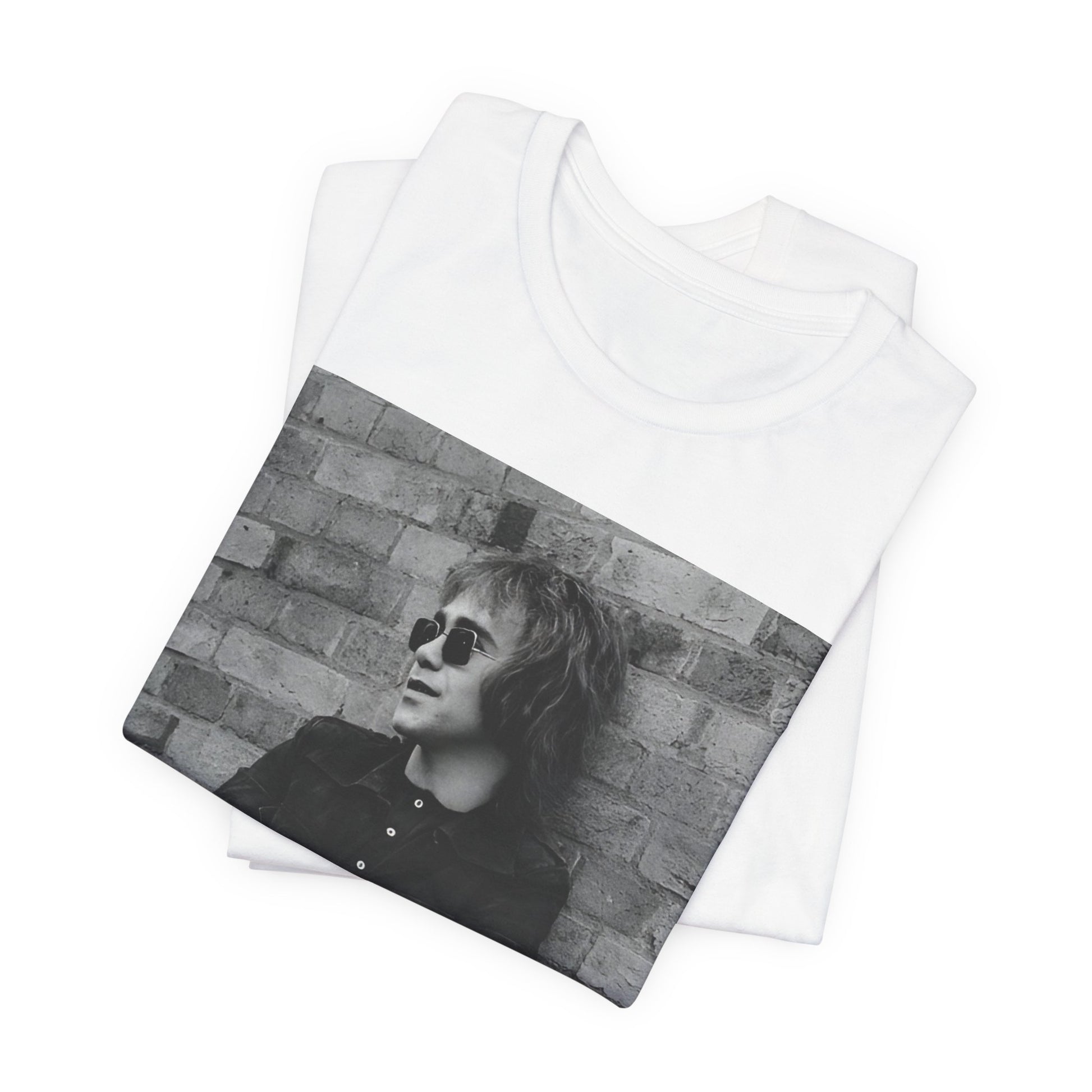 A black graphic t-shirt featuring a vintage graphic related to Elton John's 'Farewell Yellow Brick Road' tour.