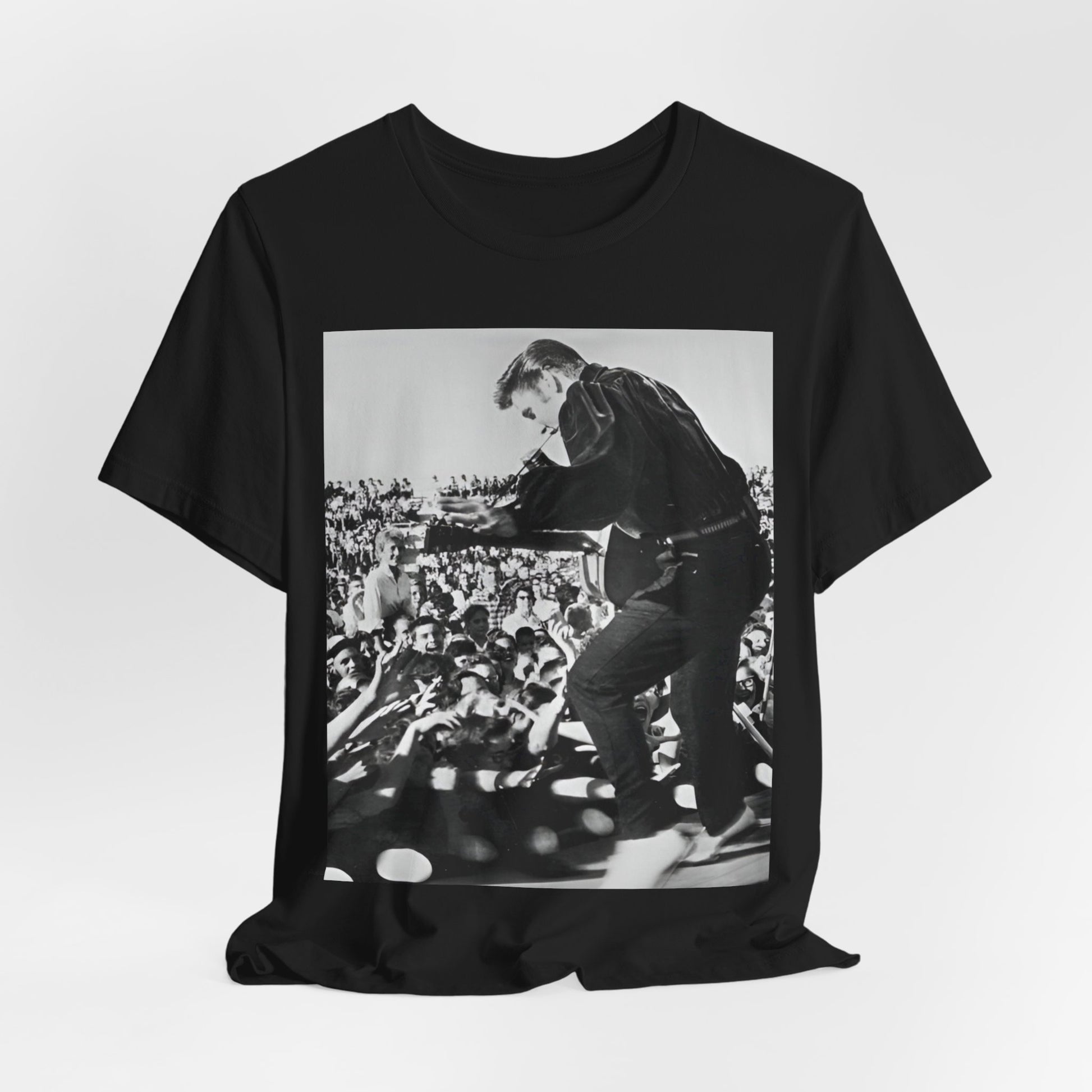 A black graphic t-shirt featuring a retro photo of Elvis Presley performing live in concert in the 1950s.