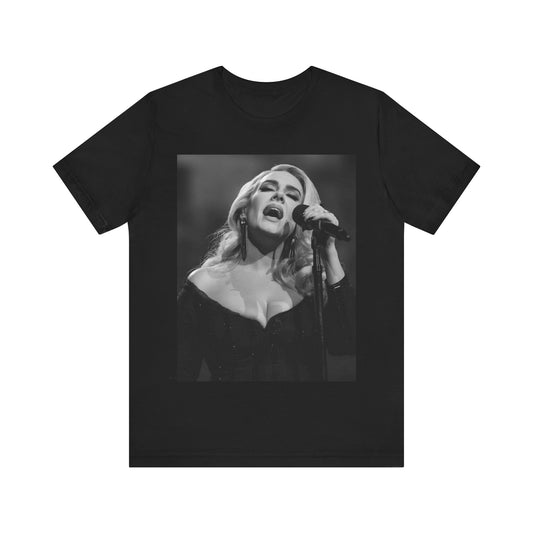 A black graphic t-shirt featuring a dynamic image of Adele performing on stage, with lighting effects, likely from her 'One Night Only' concert special.