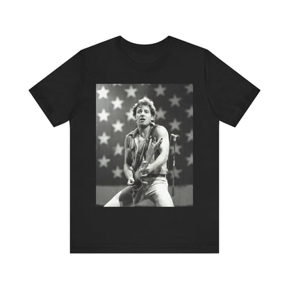 A black graphic t-shirt featuring a black and white graphic of Bruce Springsteen with an American flag background or elements.