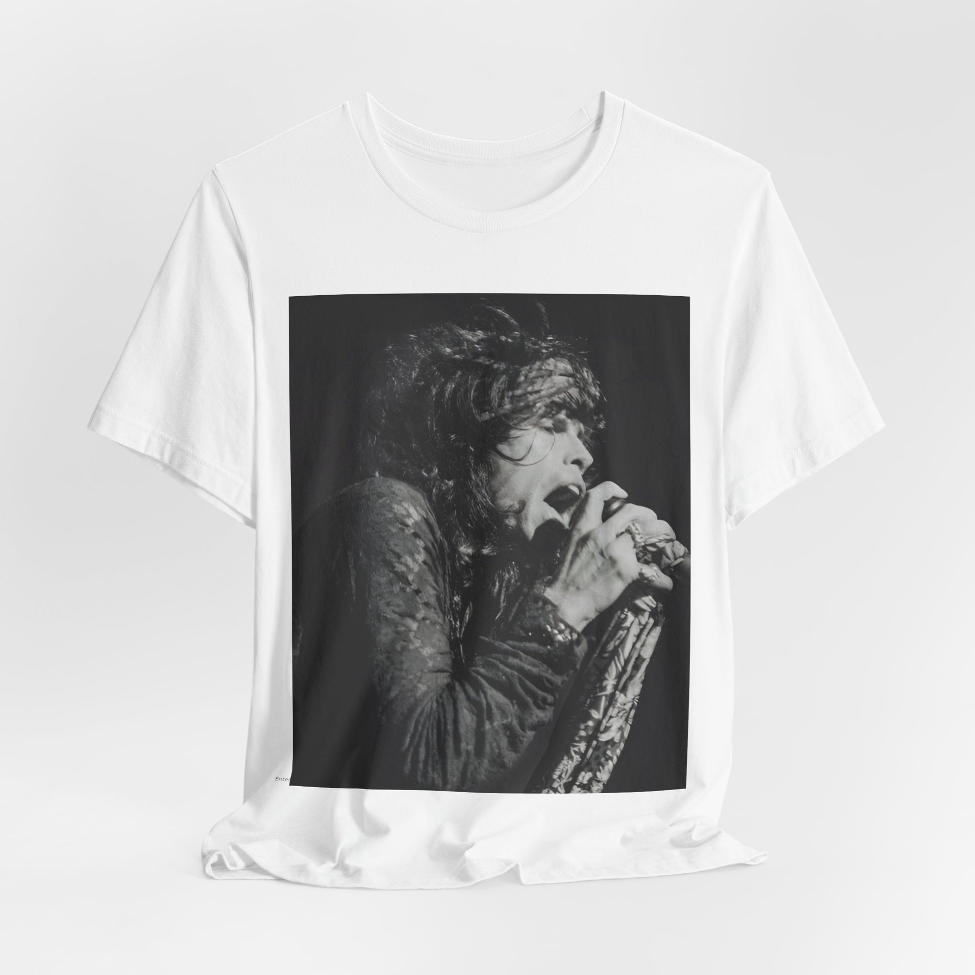 A black graphic t-shirt featuring a retro 70s-style illustration or photo of Aerosmith, designed to evoke their 'On Tour' presence, possibly with band members on stage or tour bus imagery.