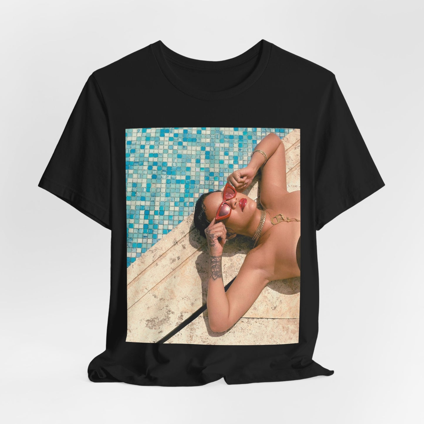A black graphic t-shirt featuring a graphic of Rihanna in swimwear as a pop star queen.