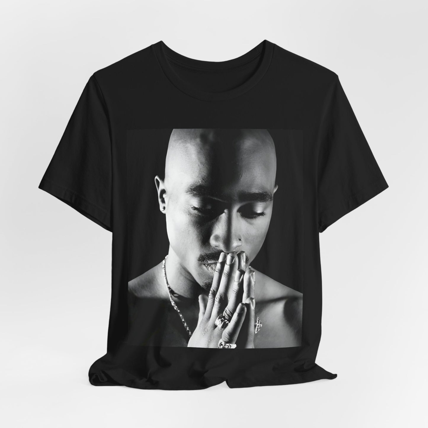 A black graphic t-shirt featuring a black and white streetwear rebel graphic of Tupac.