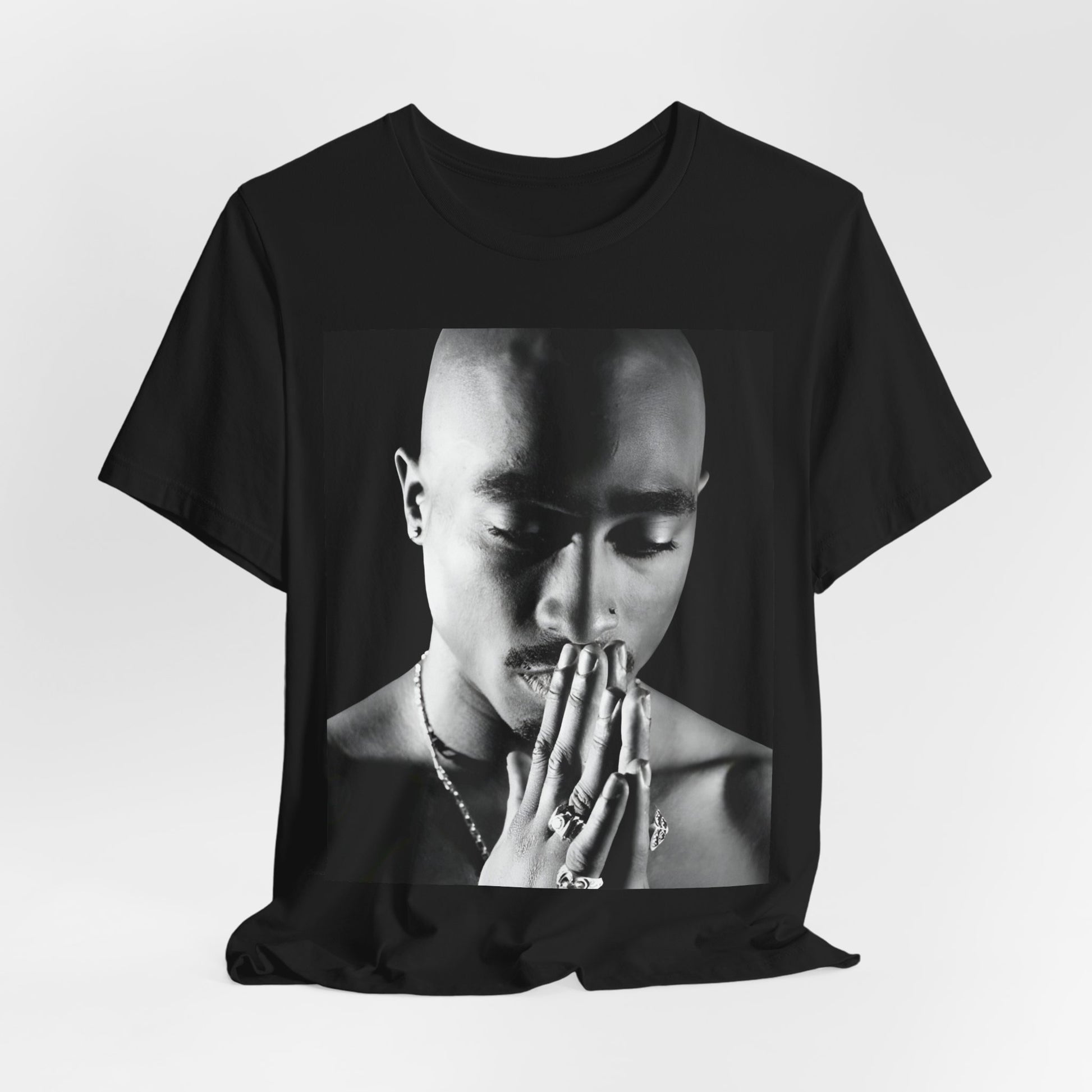 A black graphic t-shirt featuring a black and white streetwear rebel graphic of Tupac.