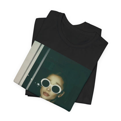 A black graphic t-shirt featuring a retro Polaroid-style photo of Ariana Grande.