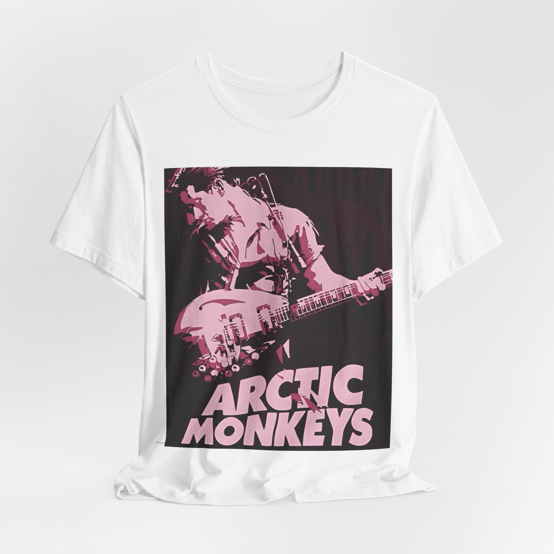 A black graphic t-shirt featuring the Arctic Monkeys logo in a prominent pink color, creating an aesthetic look.