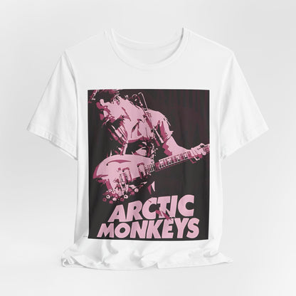 A black graphic t-shirt featuring the Arctic Monkeys logo in a prominent pink color, creating an aesthetic look.