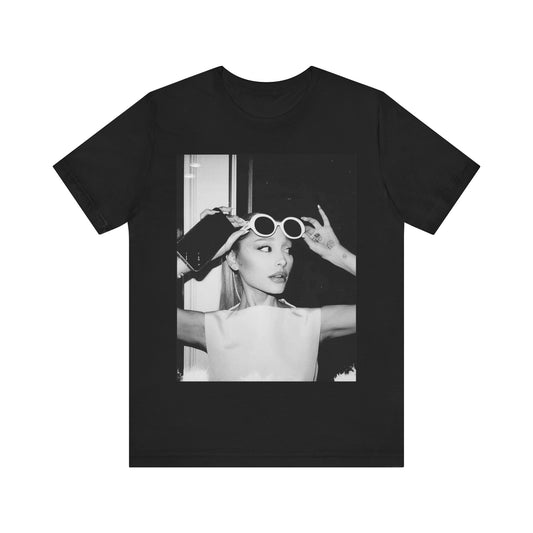 A black graphic t-shirt featuring a classic pop graphic or portrait of Ariana Grande.