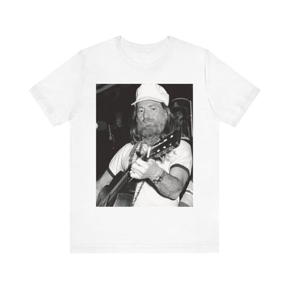 A black graphic t-shirt featuring a 70s cool free spirit graphic of Willie Nelson.