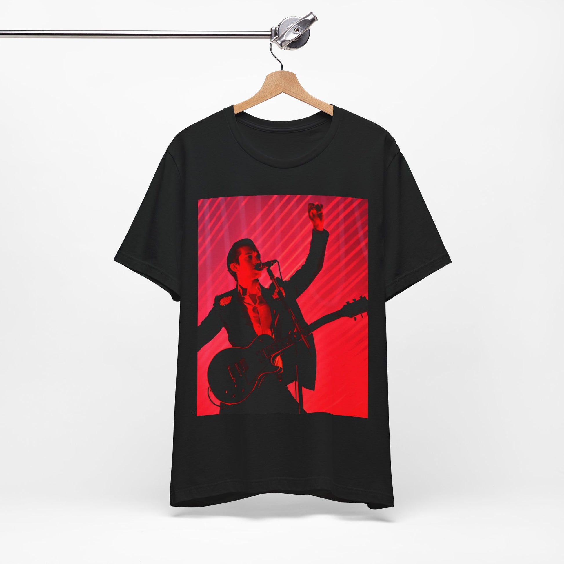 A black graphic t-shirt featuring a dynamic graphic or photo of Arctic Monkeys performing live in concert.