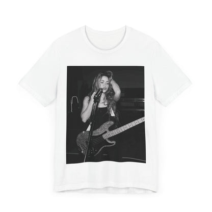 A black graphic t-shirt featuring a black and white graphic or photo of Shakira playing guitar live.