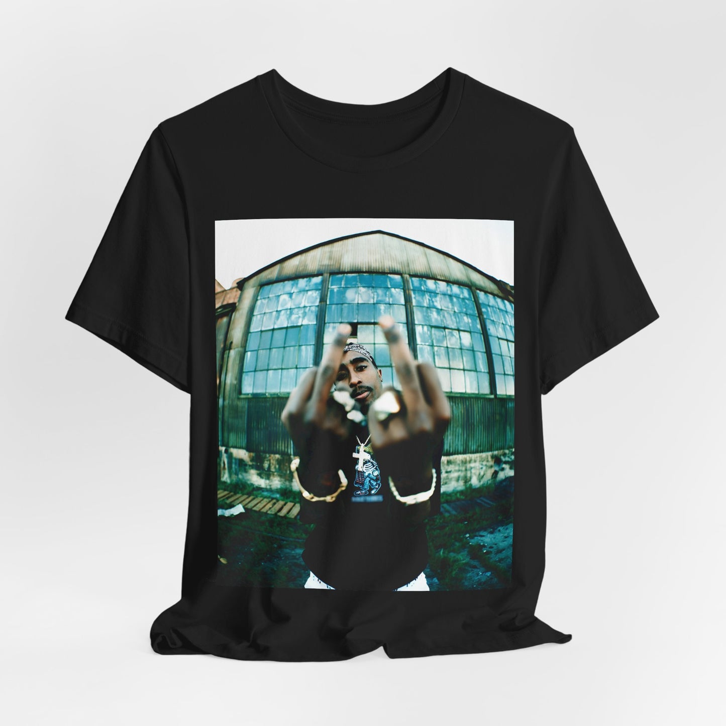 A black graphic t-shirt featuring a graphic of Tupac giving the middle finger.