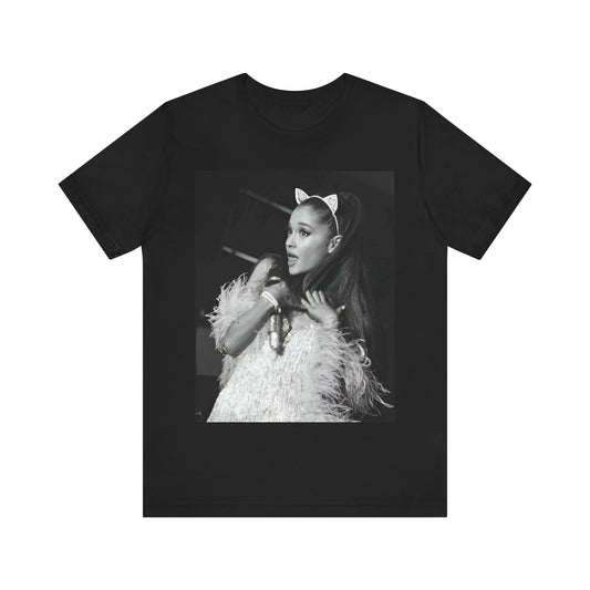 A black graphic t-shirt featuring Ariana Grande wearing her signature cat ears, in a graphic or photo style.