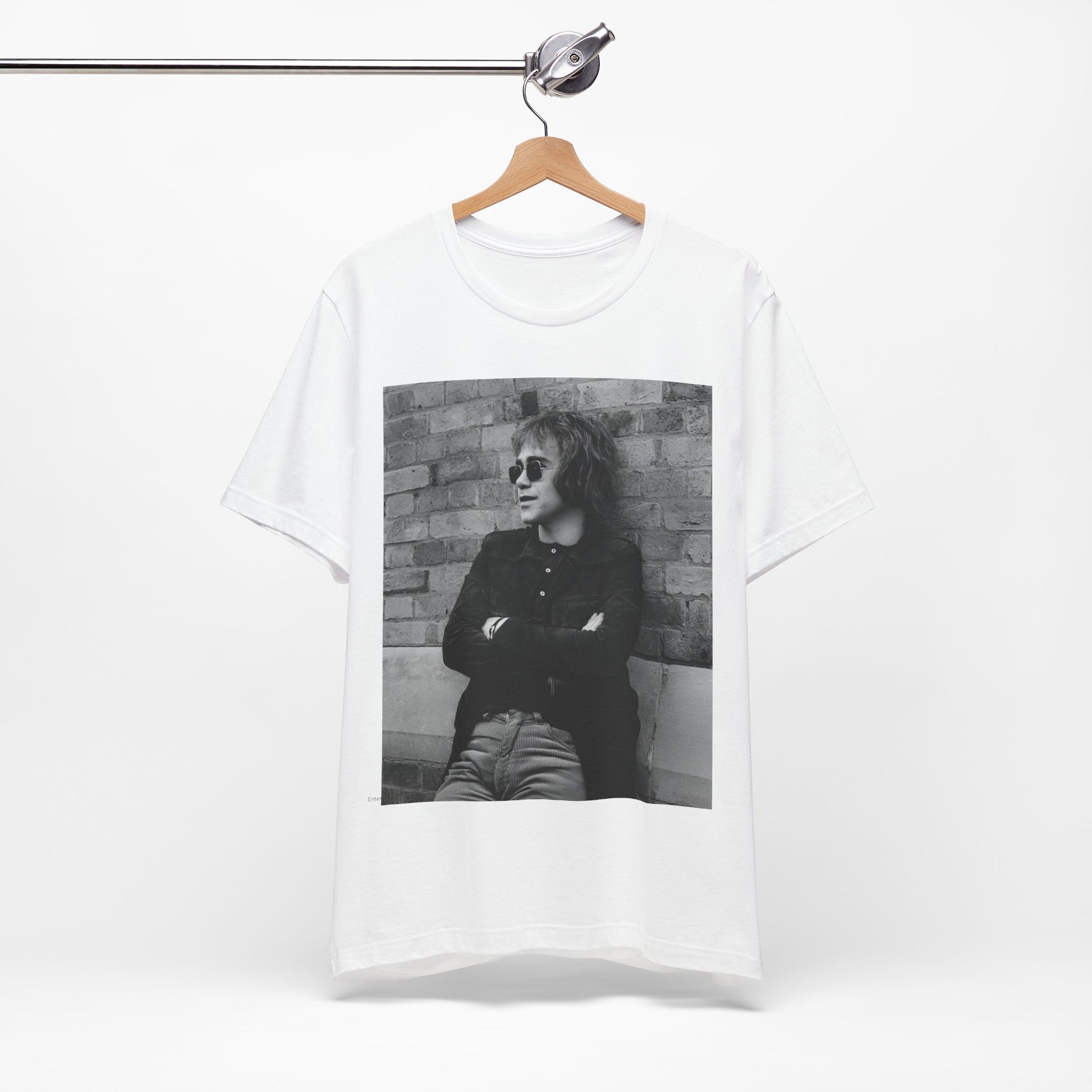 A black graphic t-shirt featuring a vintage graphic related to Elton John's 'Farewell Yellow Brick Road' tour.