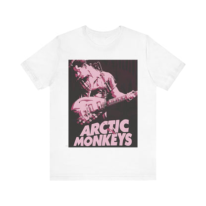 A black graphic t-shirt featuring the Arctic Monkeys logo in a prominent pink color, creating an aesthetic look.