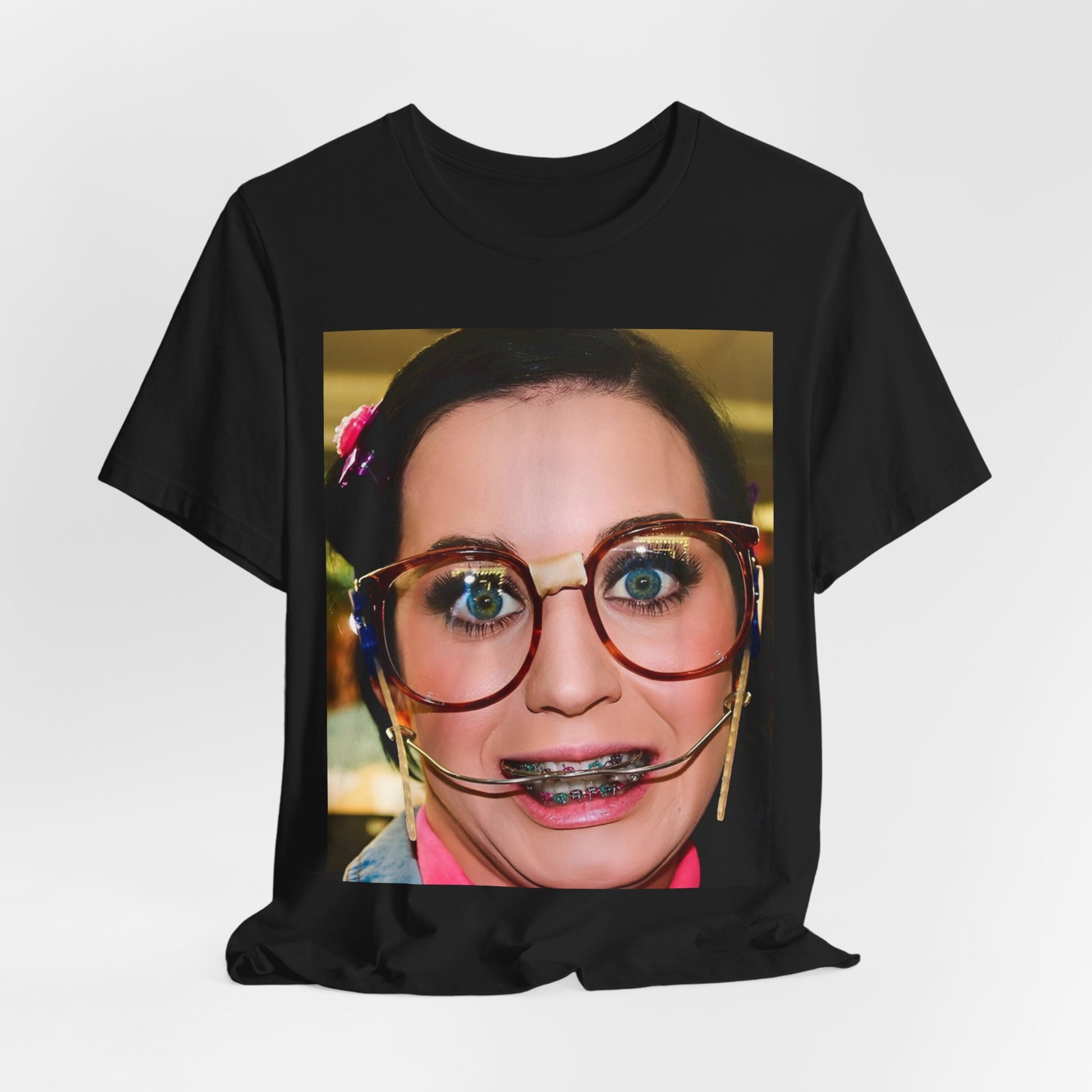 A black graphic t-shirt featuring a graphic related to Katy Perry's "I Kissed A Girl" song or era.