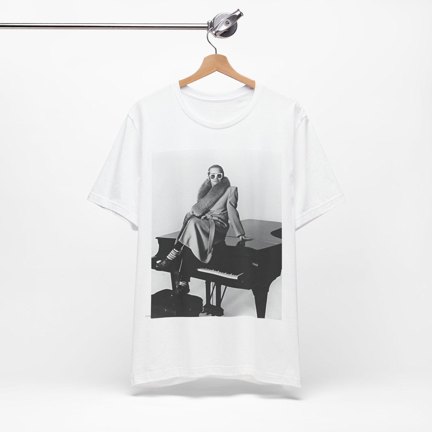 A black graphic t-shirt featuring a black and white photo of Elton John playing the piano.