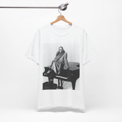 A black graphic t-shirt featuring a black and white photo of Elton John playing the piano.