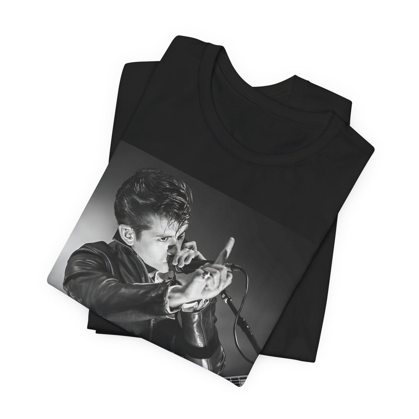 A black graphic t-shirt featuring a dynamic black and white graphic or photo of Arctic Monkeys performing live, emphasizing energy.