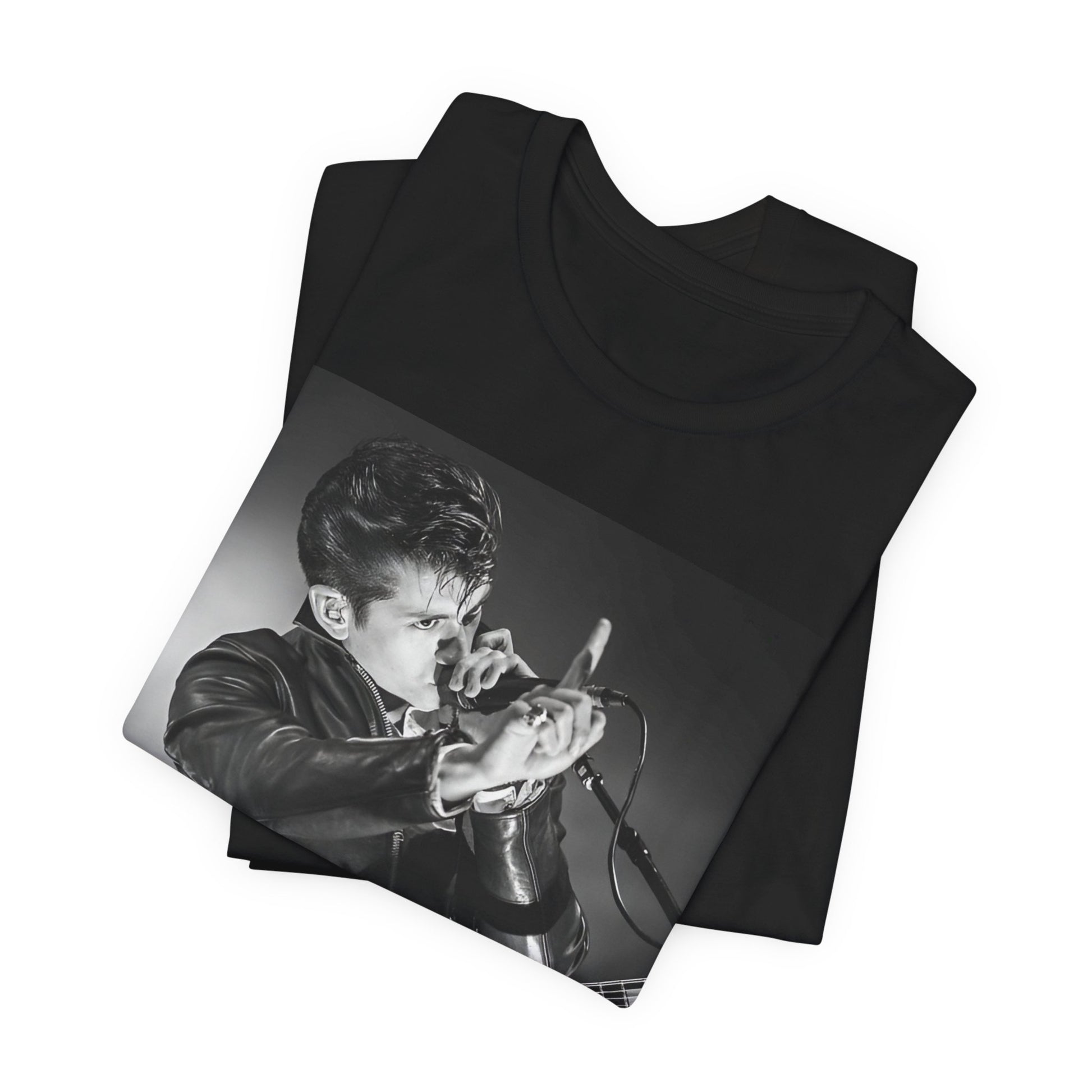 A black graphic t-shirt featuring a dynamic black and white graphic or photo of Arctic Monkeys performing live, emphasizing energy.
