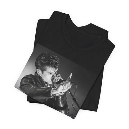 A black graphic t-shirt featuring a dynamic black and white graphic or photo of Arctic Monkeys performing live, emphasizing energy.