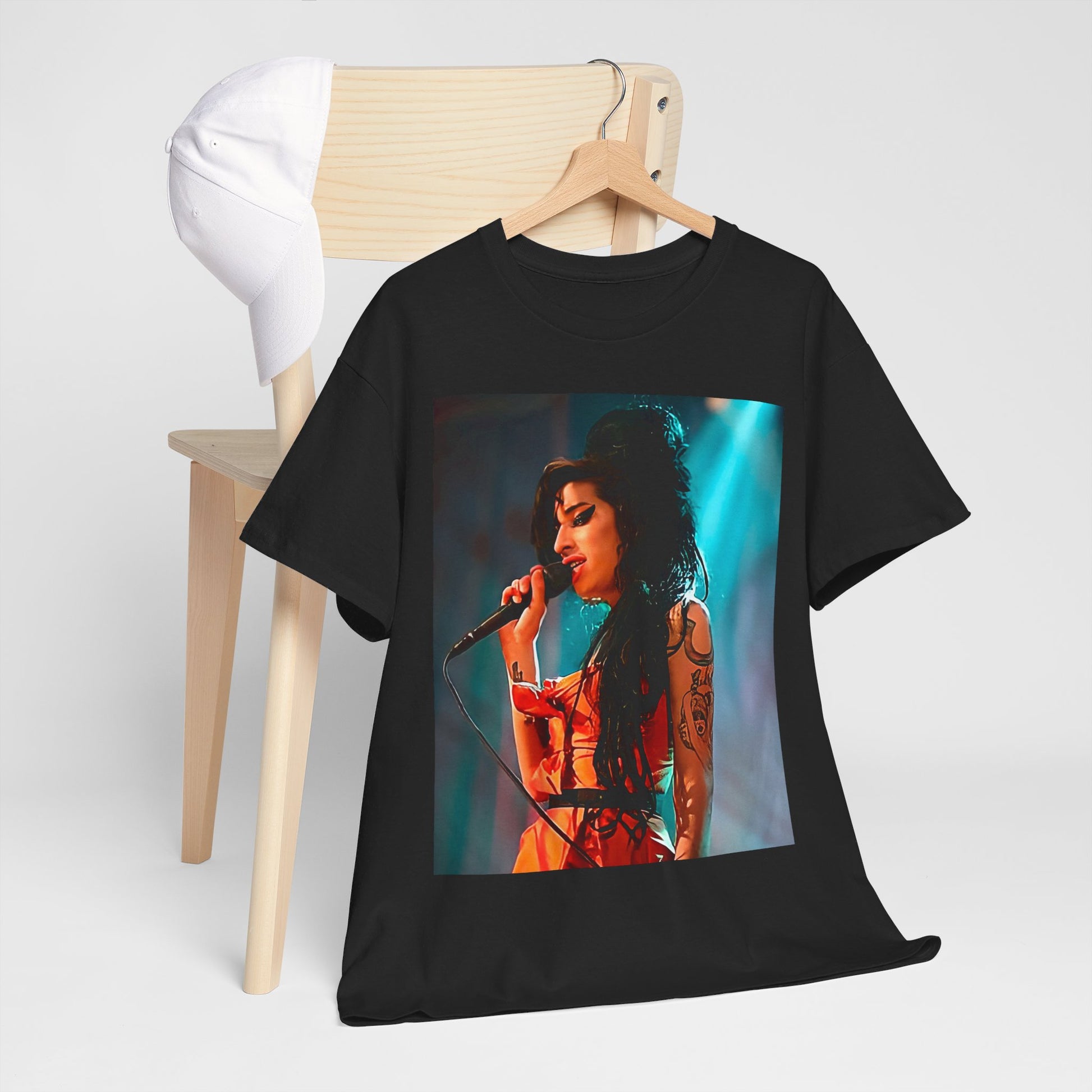 A black graphic t-shirt featuring a photo of Amy Winehouse performing live on stage in 2007, with her signature beehive and expressive singing.