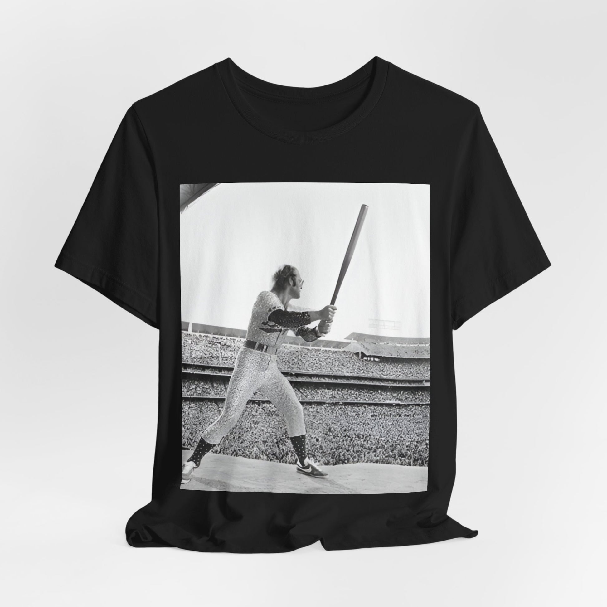 A black graphic t-shirt featuring a black and white graphic or photo related to Elton John's 1975 tour in America.