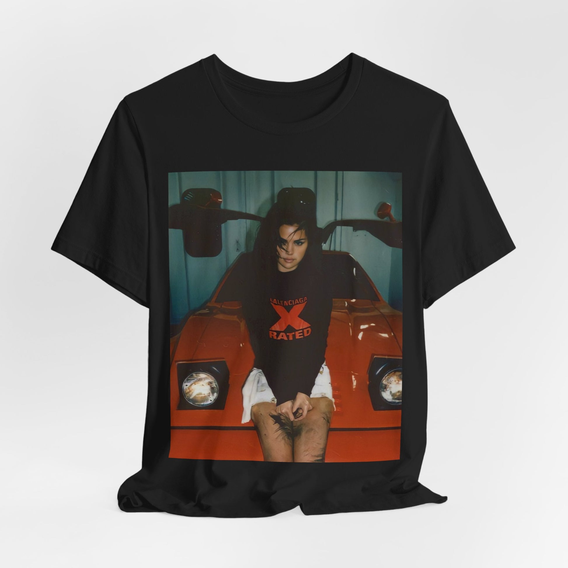 A black graphic t-shirt featuring a photo or graphic of Selena Gomez with a car, designed with an 'X Rated' or edgy aesthetic.