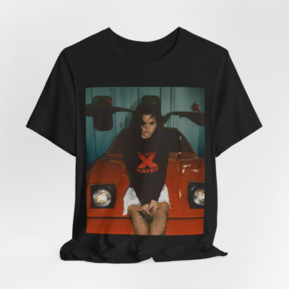 A black graphic t-shirt featuring a photo or graphic of Selena Gomez with a car, designed with an 'X Rated' or edgy aesthetic.