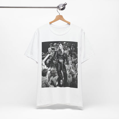 A black graphic t-shirt featuring a vintage black and white photo or graphic of Elvis Presley performing live on stage.