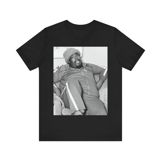 A black graphic t-shirt featuring a 70s-style portrait photo of Barry White in a lounge setting.
