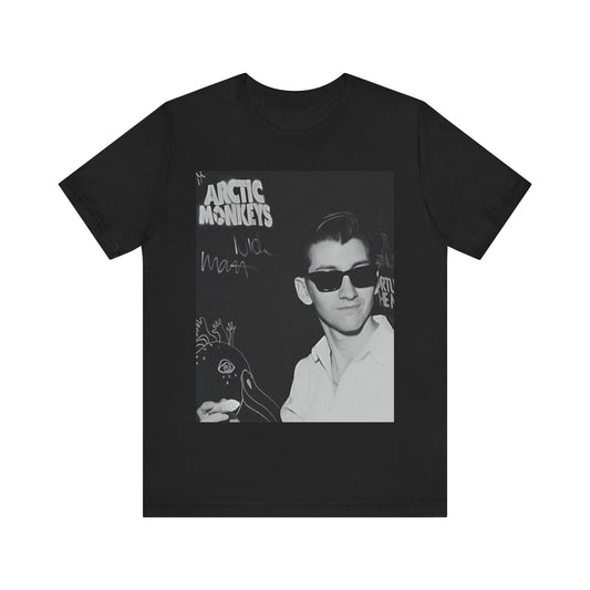 A black graphic t-shirt featuring a black and white portrait photo of Alex Turner from Arctic Monkeys, showing his signature look.