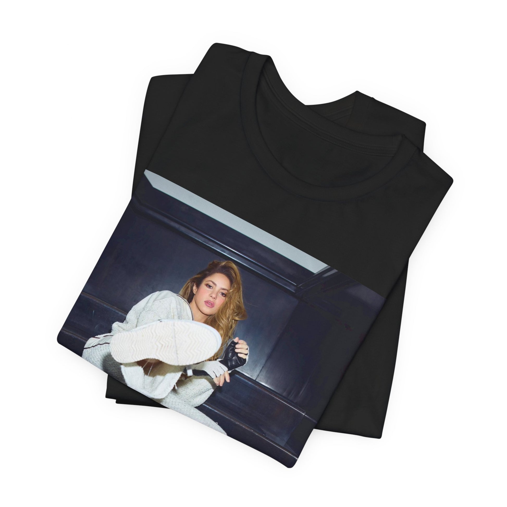 A black graphic t-shirt featuring a vintage Latin pop icon graphic of Shakira.