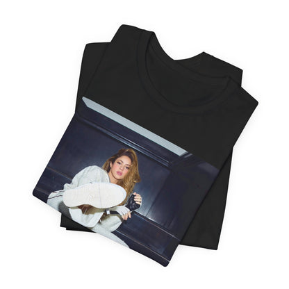 A black graphic t-shirt featuring a vintage Latin pop icon graphic of Shakira.