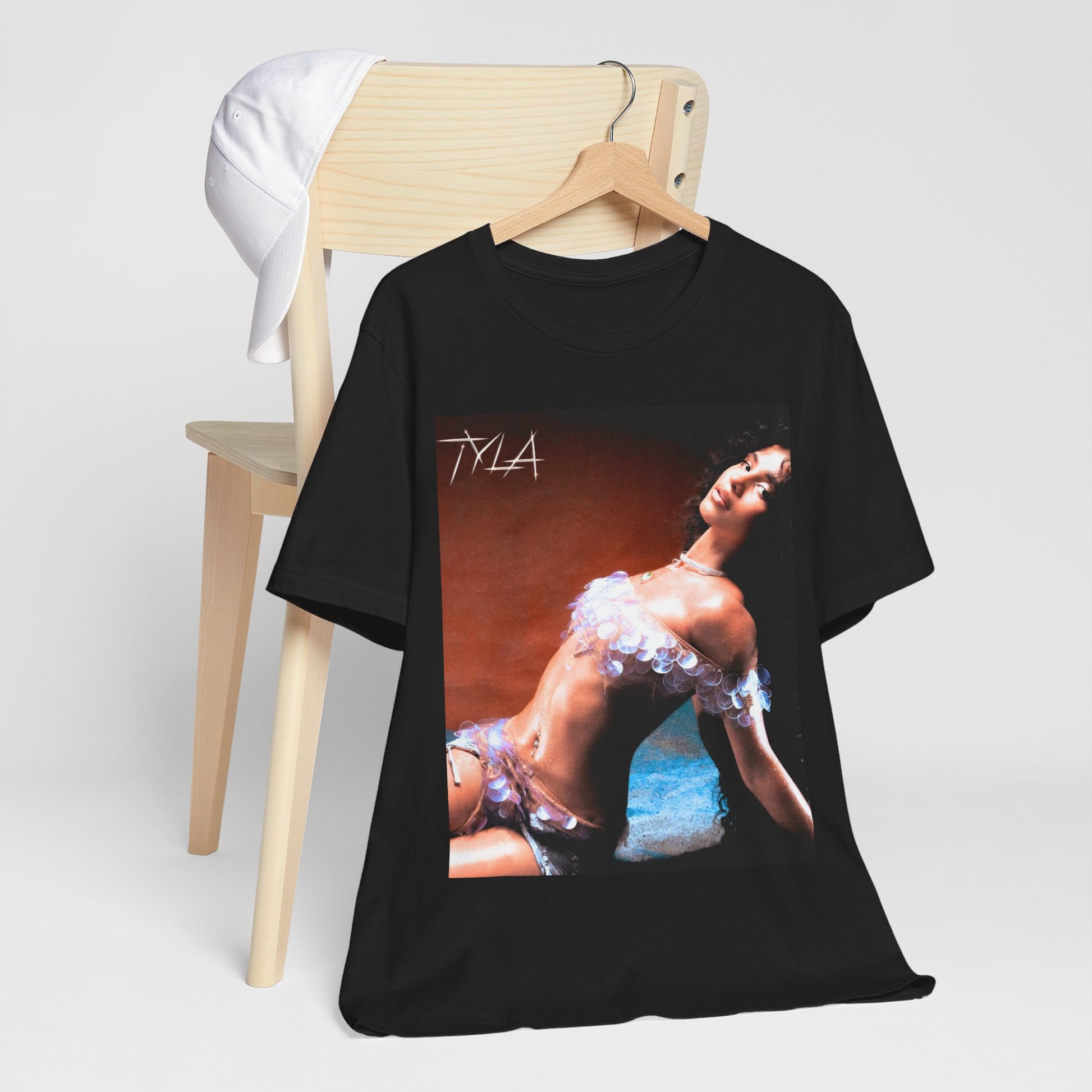 A black graphic t-shirt featuring a cultural fusion vibes graphic of Tyla.