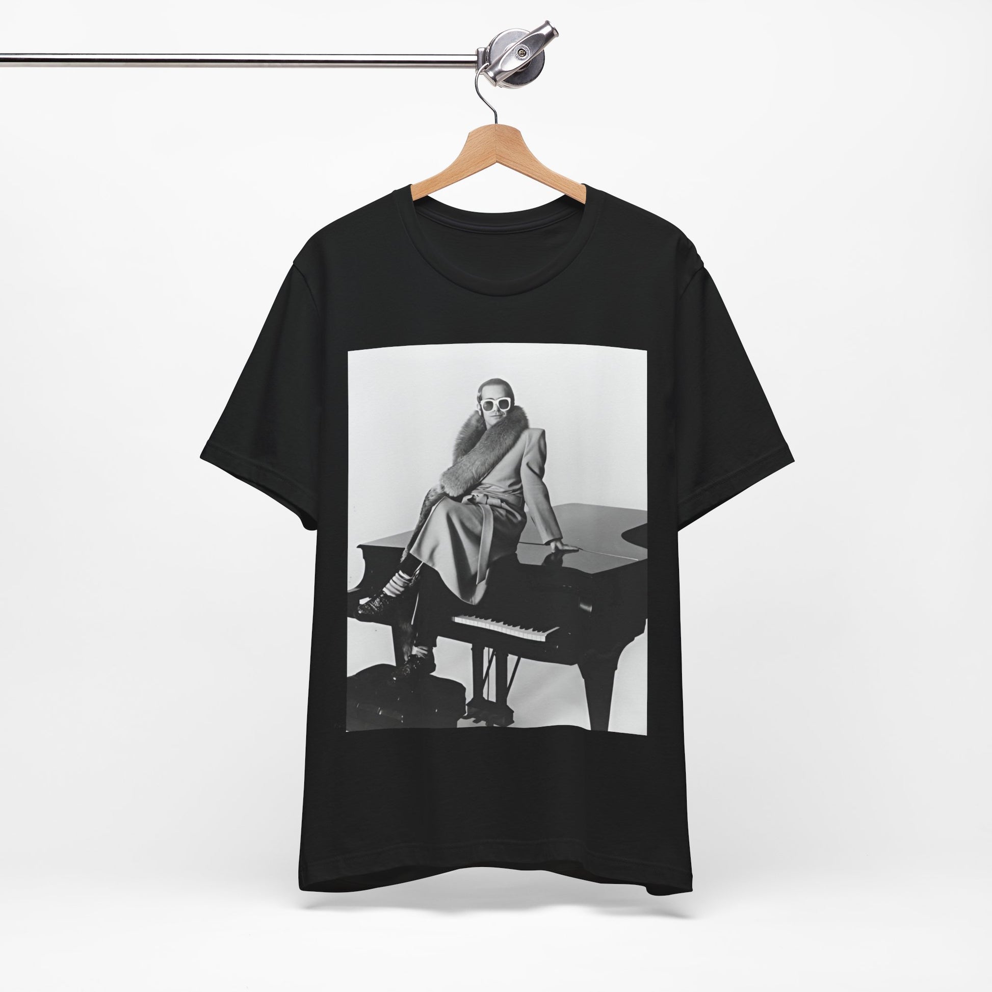A black graphic t-shirt featuring a black and white photo of Elton John playing the piano.