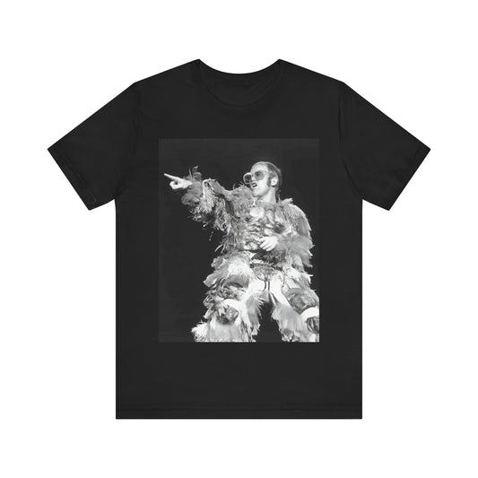 A black graphic t-shirt featuring a retro graphic of Elton John as a rock legend performing live.