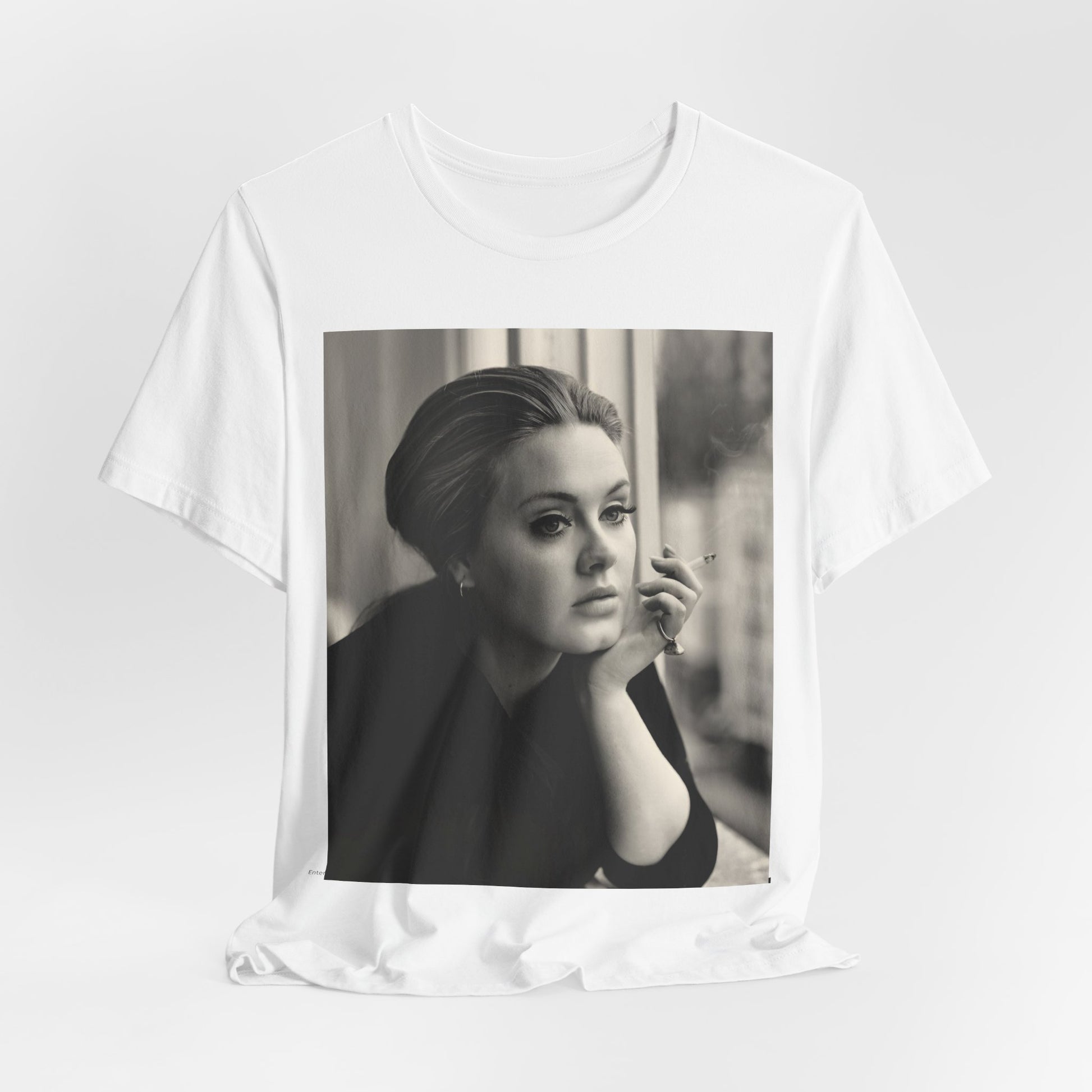 A black graphic t-shirt featuring a black and white photo of Adele, showing her with a serene or thoughtful expression.