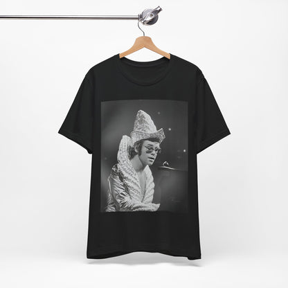 A black graphic t-shirt featuring a 70s pop aesthetic graphic of Elton John.
