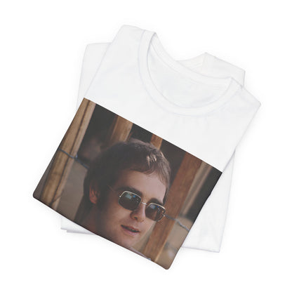 A black graphic t-shirt featuring a classic graphic related to Elton John's 'Tiny Dancer' song or era.