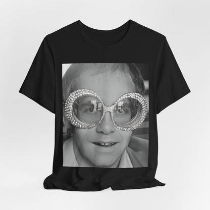 A black graphic t-shirt featuring a graphic of Elton John emphasizing his iconic glasses and fashion.
