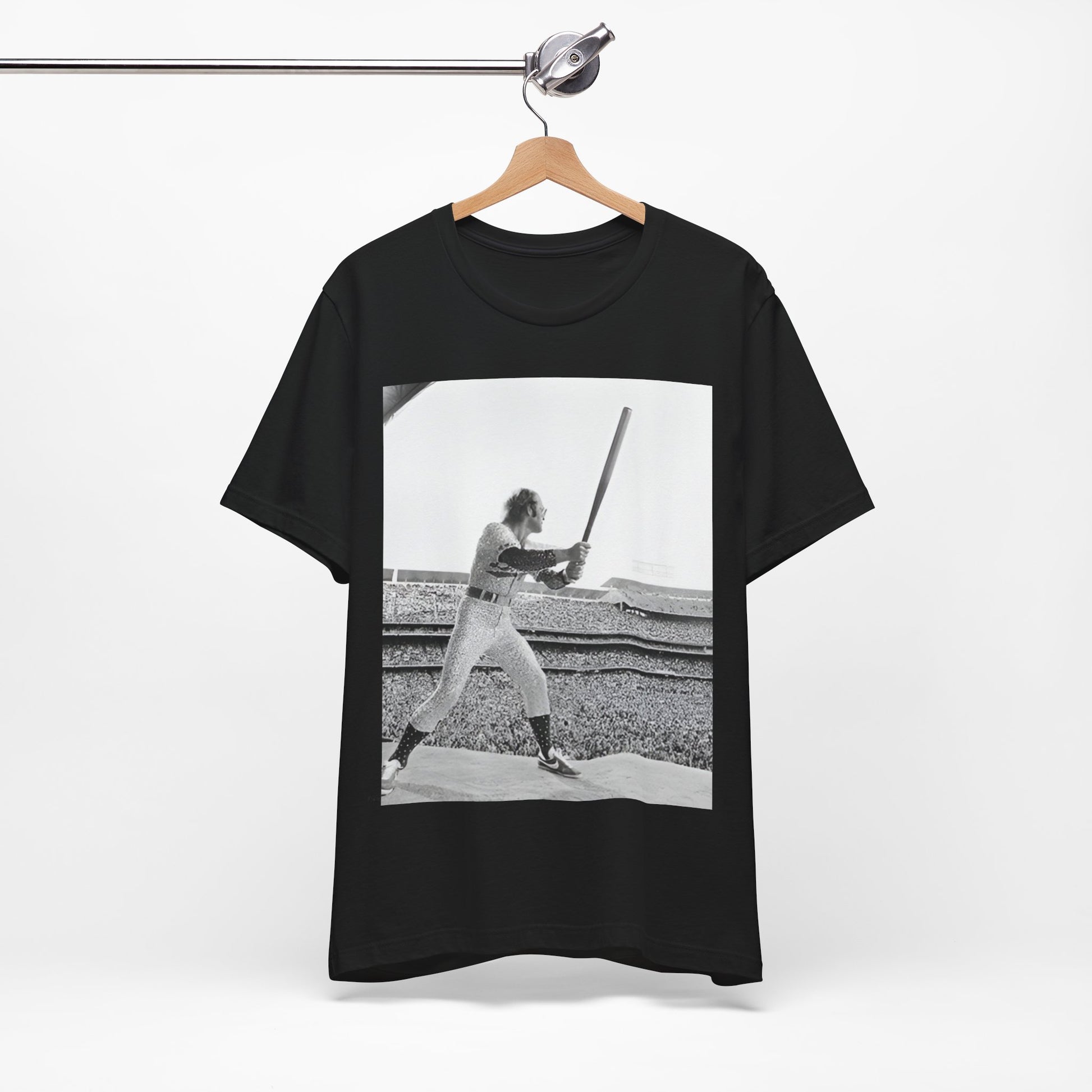 A black graphic t-shirt featuring a black and white graphic or photo related to Elton John's 1975 tour in America.